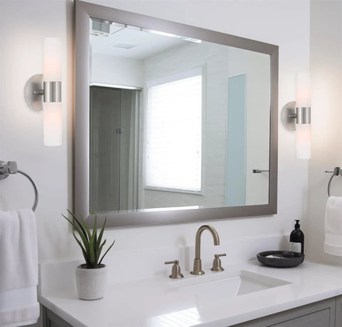 Modern 14 Inch Two Light Wall Sconce in Brushed Nickel Finish with Frosted Glass Cylinder Shades beside bathroom mirror