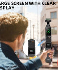 Person using High Capacity Battery Handle For Osmo Pocket 3 And 4 On The Go 5000mAh Power Grip with Mini Tripod in urban setting