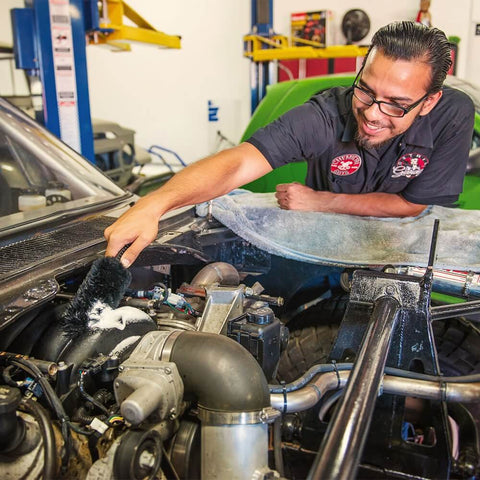 Man cleaning car engine using Soft Natural Bristle Wheel And Rim Cleaning Brush With Gerbil Hair For Wheels Rims Exhaust Tips