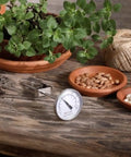 Soil Temperature Thermometer With 4 Inch Stem For Plant Care And Lawn Garden Monitoring Measures 2 Inches Deep 20 To 180 Degrees Fahrenheit And 0 To 80 Celsius Heavy Duty Stainless Steel With Stem Clip For Easy Attachment Ideal For Planting Timings on wooden table with plants and seeds
