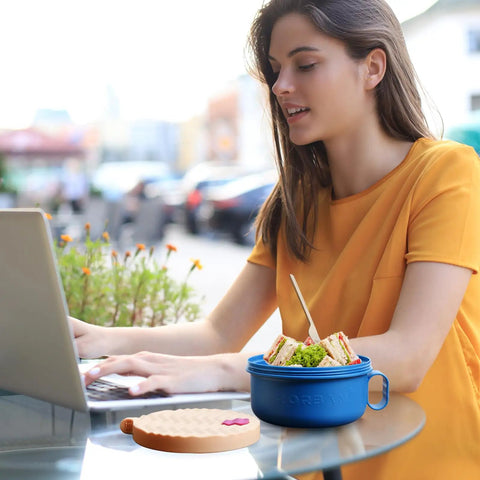 Ramen Cooker Microwave Bowl 48 Oz Ramen Noodle Bowl For Dorm Rooms And Apartments BPA Free Pink Must Have For Busy Students Ideal College Kitchen Essential shown on outdoor table next to laptop and woman.