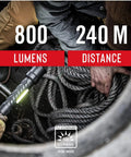 Man holding Polysteel 700 LED Flashlight 800 Lumens Heavy Duty Stainless Steel Core for outdoor use.