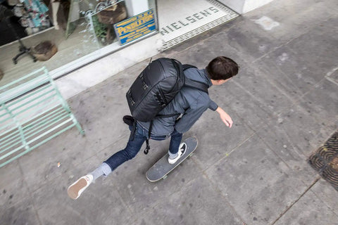 Person skateboarding with Freeline Camera Backpack 350 AW With QuickShelf System 3 Tier Shelving Or Flat Fold Urban setup