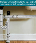 Peel And Stick Outdoor Foam Pipe Insulation Tape 2 Inch By 33 Feet Aluminum Finish installed on plumbing pipes under sink.