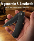 Folding Pocket Knife With 3.23 Inch Stainless Steel Blade And G10 Handle Pocket Clip EDC Knife held in hand on table