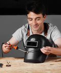 Man using Dual Power Plastic Welder Kit with 60W and 100W soldering iron on black plastic item on workbench.