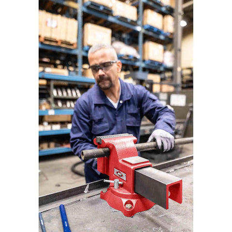 Worker securing material with Swivel Bench Vise Six Inch Opening With Three And A Half Inch Throat, 360 Degree Rotating Base With Lock Down