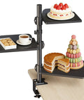 Black 3 Tier Clamp On Desk Shelf with Height Adjustment and 360 Degree Rotatable Tray displaying desserts and coffee