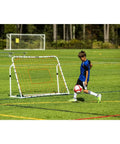 Child using Adjustable Soccer Rebounder 6 Foot By 4 Foot For Training with Angles on a field.