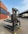 Heavy Duty Electric Pallet Stacker With Wireless Remote Control 661 Lb Capacity 4 Foot Lift Height And Adjustable Forks in warehouse setting.