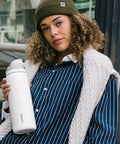 Top Tier Insulated Stainless Steel Water Bottle 32 Oz With Chill FreeSip Dual Drink Modes Secure Push Button Lock Lid in hand outdoors.