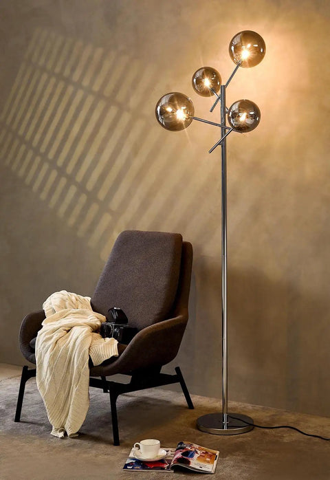 Sputnik 4 Light Floor Lamp With Smoky Grey Glass Globes, Chrome Finish, beside a chair and blanket in modern interior