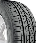 Close-up of a car tire with detailed tread pattern, showcasing durable rubber design and sidewall markings on alloy wheel.