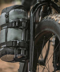 VersaCage Adventure Cage With Adjustable Mounting System And VersaMount Clamps And Straps holding a dry bag on a bike fork