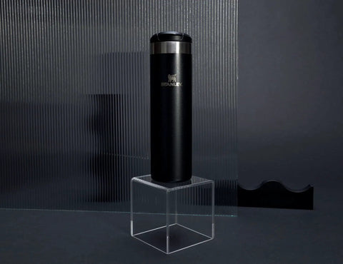 20 Oz Leakproof Stainless Steel Travel Bottle With Locking Lid Vacuum Insulated Double Wall Keeps Drinks Hot For 4 Hours Or Cold For 6 Hours BPA Free Lightweight Black Glimmer Ideal For Coffee Or Water On The Go standing on a clear pedestal against a dark background.