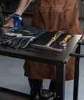 Heavy Duty Welding Table Workbench With Rock Solid 1200 Pound Capacity Plus 36 By 18 Inch Surface Rust Proof Finish Made For Busy Shop Floors Garage Crews And Fabricators Built To Last with tools and gloves on top.