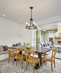 Wagon Wheel Black Farmhouse Chandelier With 4 Lights above dining table, warm rustic glow enhancing cozy dining room atmosphere.