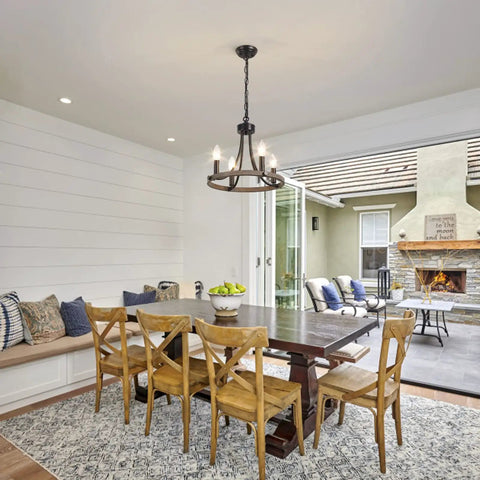 Wagon Wheel Black Farmhouse Chandelier With 4 Lights above dining table, warm rustic glow enhancing cozy dining room atmosphere.