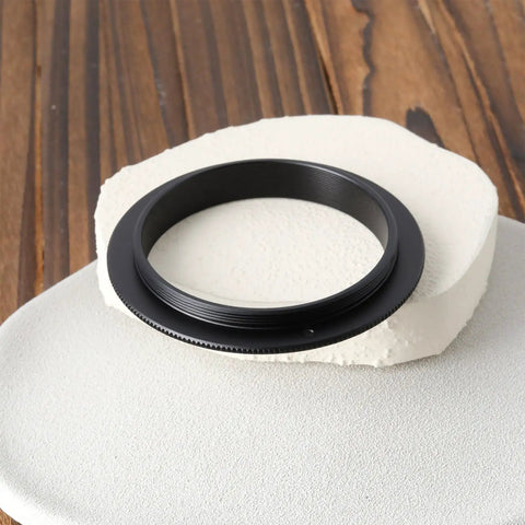 Male To Male M54x0.75 Telescope Adapter Ring For 50Mm Lens Filter resting on textured surface