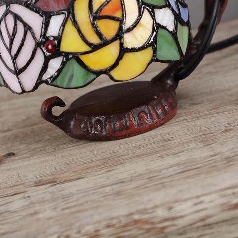 Close-up of Rose Tiffany Style Stained Glass Table Lamp With Six Inch Lampshade on sturdy cast iron base, colorful design
