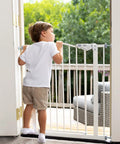 Child standing near Adjustable Baby Gate For Pets 29 To 39.6 Inches Wide, 30 Inch Tall, Auto Close On Both Sides, White.