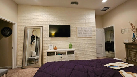 Dope 3D Brick Wall Sticker Kit, 10 Large PE Foam Tiles behind a TV in a cozy bedroom setting. Self adhesive, waterproof wallpaper decor.
