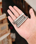 Hand holding Six Piece Tap Extractor Set For Stripped Screws And Bolts, high speed steel flute remover tools.