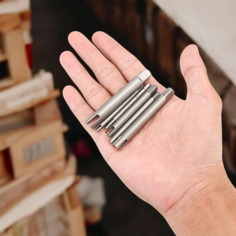 Hand holding Six Piece Tap Extractor Set For Stripped Screws And Bolts, high speed steel flute remover tools.