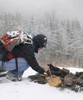 Person using Six Pack Natural Jute Fire Starters For Quick Ignition Outdoor Camping Survival Tool For Easy Fires in snowy forest.