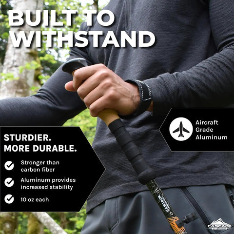 Close-up of hands holding a Pair Of Adjustable Trekking Poles With Aircraft Grade Aluminum, Cork Grip, in a forest setting.