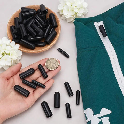 25 Piece Silicone Zipper Protector Covers Guards Set For Laundry Care Includes Five Universal Sizes In Black To Prevent Snags And Damage During Washing Machine And Dryer Use, displayed with a zipper and a coin for size reference.