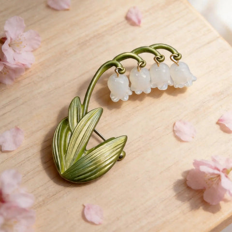 Delicate Lily Of The Valley Brooch For Women Featuring Tiny Bell Shaped Petals Lightweight Floral Pin on wooden surface.