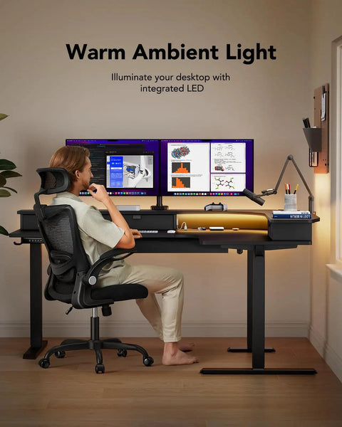 Person at 65 Inch L Shaped Standing Desk With Power Outlets And LED Strip, Electric Height Adjustable Corner Computer Desk For Home Office.