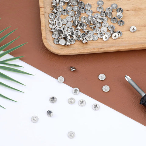 Hardcore Stainless Steel Chicago Screw Rivets Kit With Phillips Heads And 50 Pack of shiny reusable fasteners on a wooden tray.