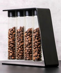 Keep Your Grind Fresh With This Premium Airtight Coffee Bean Storage Tube Set Featuring Four Smart Glass Jars And Clean Counter Display One Way Valve Seals In Aroma For Smooth Daily Brewing, showcasing four glass jars filled with coffee beans.