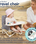 Baby using OmniBoost Travel Booster Seat With Tray on beach alongside adult reading book