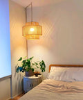 Plug In Pendant Light With Smooth Dimmable Switch And Handwoven Boho Rattan Shade over a bed in a cozy bedroom.
