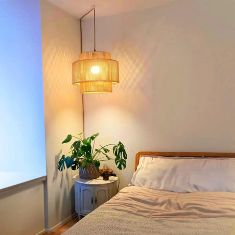 Plug In Pendant Light With Smooth Dimmable Switch And Handwoven Boho Rattan Shade over a bed in a cozy bedroom.