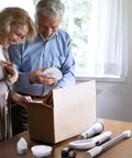 Couple unboxing Cordless Spin Scrubber With LED Display And Detachable D Shape Handle, battery, and cleaning attachments on table