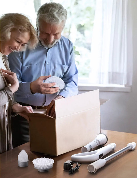 Couple unboxing Cordless Spin Scrubber With LED Display And Detachable D Shape Handle, battery, and cleaning attachments on table
