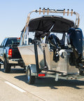 Truck towing boat secured with Beefy Retractable Transom Boat Tie Down Straps 2x43-Inch With 2500Lb Break Strength Auto Retract