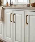 10 Pack Antique Brass Cabinet Pulls, 5 Inch Length, installed on white kitchen cabinet doors.