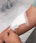 Person applying Absorbent Cushion Care Sterile Square Gauze Pads For First Aid Non Adhesive Wound Dressing 4 By 4 Inches on arm.