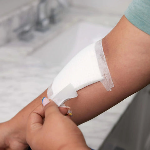 Person applying Absorbent Cushion Care Sterile Square Gauze Pads For First Aid Non Adhesive Wound Dressing 4 By 4 Inches on arm.