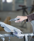 Person using 20-30 Grit Crushed Glass Abrasive For Sand Blasting And Cabinet Use on metal surface in workshop