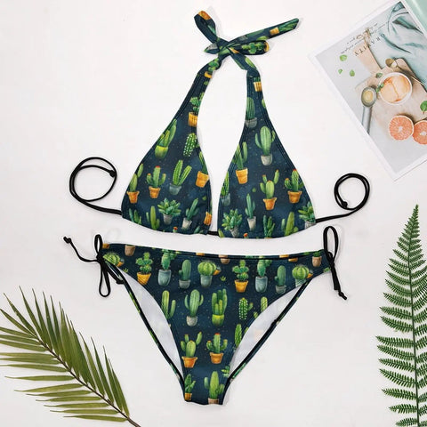 Two Piece Halter Swimsuit Set For Women With Green Cactus Flower Print Botanical Tankini Style Yacht Ready Beachwear Soft Stretch Fabric Plus Size 2XL laid out flat on white background with leaves and magazine.