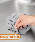 Five Pack Flower Shaped Silicone Hair Catcher Shower Drain Cover With Strong Suction Cups Killer Clog Stopper For Kitchen Bathroom Tub slick design being lifted from a sink.