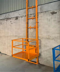 Heavy Duty Electric Lift Platform Table For Warehouse Use, Built Tough Steel Cargo Hoist With One Click Smooth Operation, Handles Up To 400kg Loads Like A Cinch Every Single Day Reliable, featuring an orange motorized lifting platform against a concrete wall.