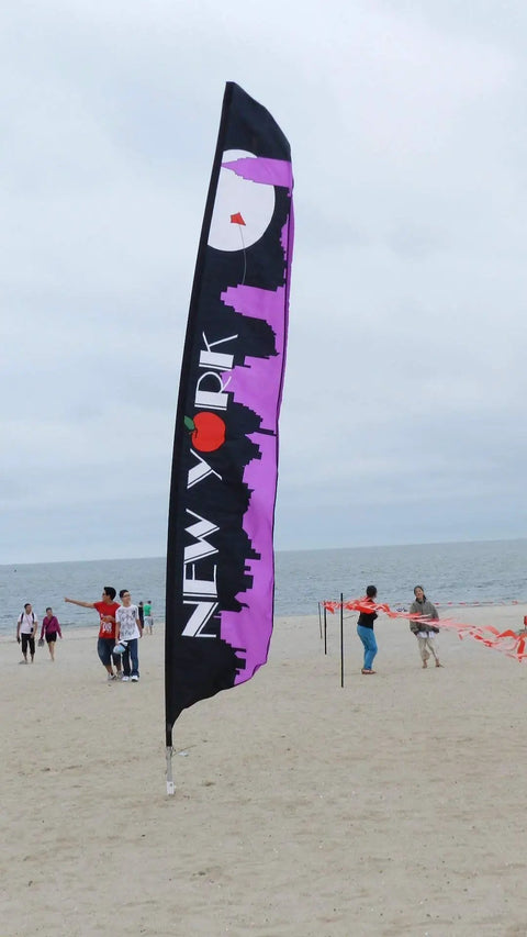 Large New York flag on a beach with skyline silhouette, secured by a 46 Inch Aluminum Screw Ground Anchor With 1/2 Inch Guying Slot