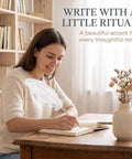 White Retro Feather Ballpoint Pen Smooth Riding Signature Pen For Weddings And Office Gifts Elegant Refillable Writer Hits Different With Slick Ink Flow Perfect For Guest Books Journaling And Snappy Notes, being used by a woman on a wooden desk.